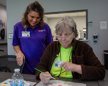 BoldAge PACE Owensboro staff member overseeing participant painting